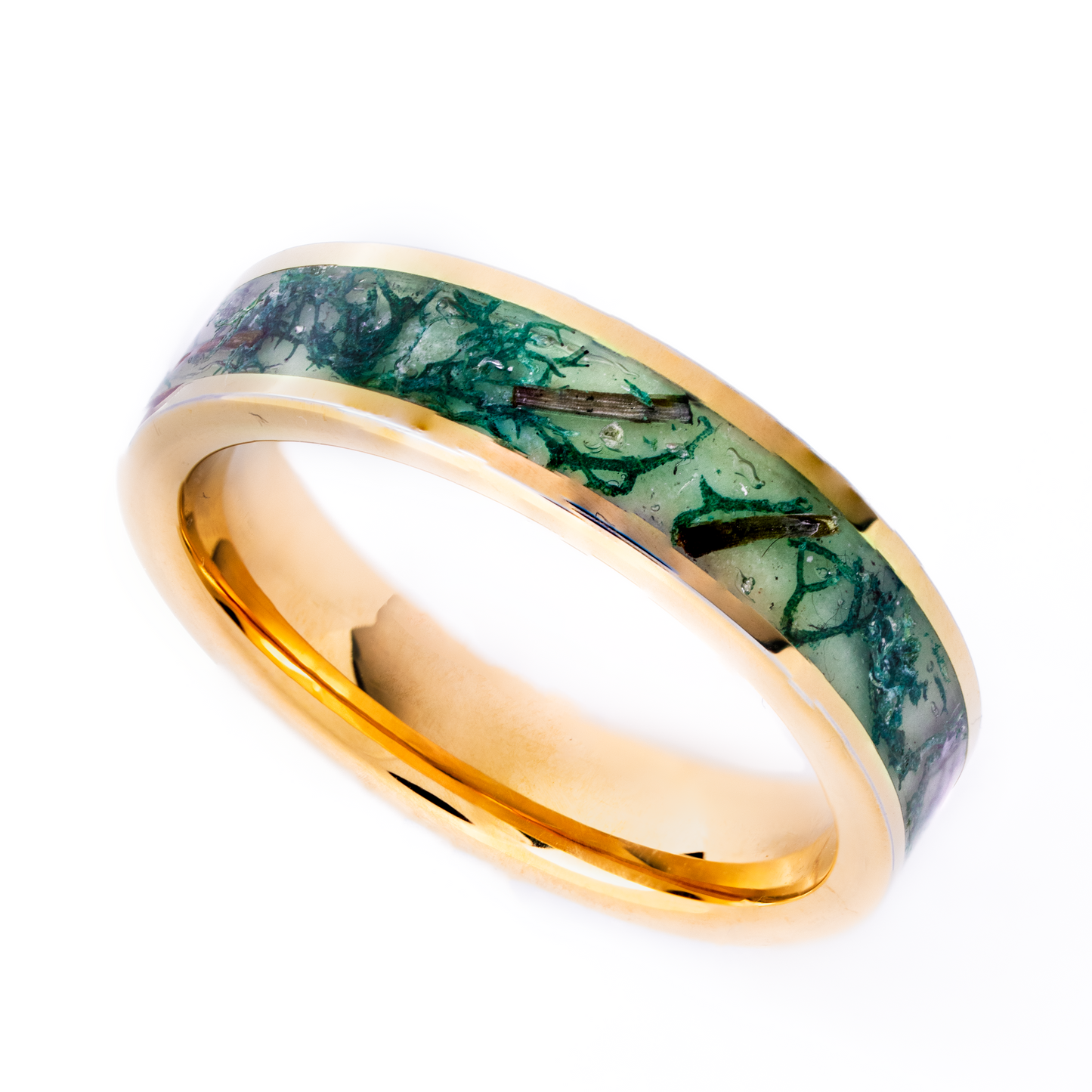 Gold plated tungsten ring with green glow in the dark powder, dried moss, and twigs inside on a white background