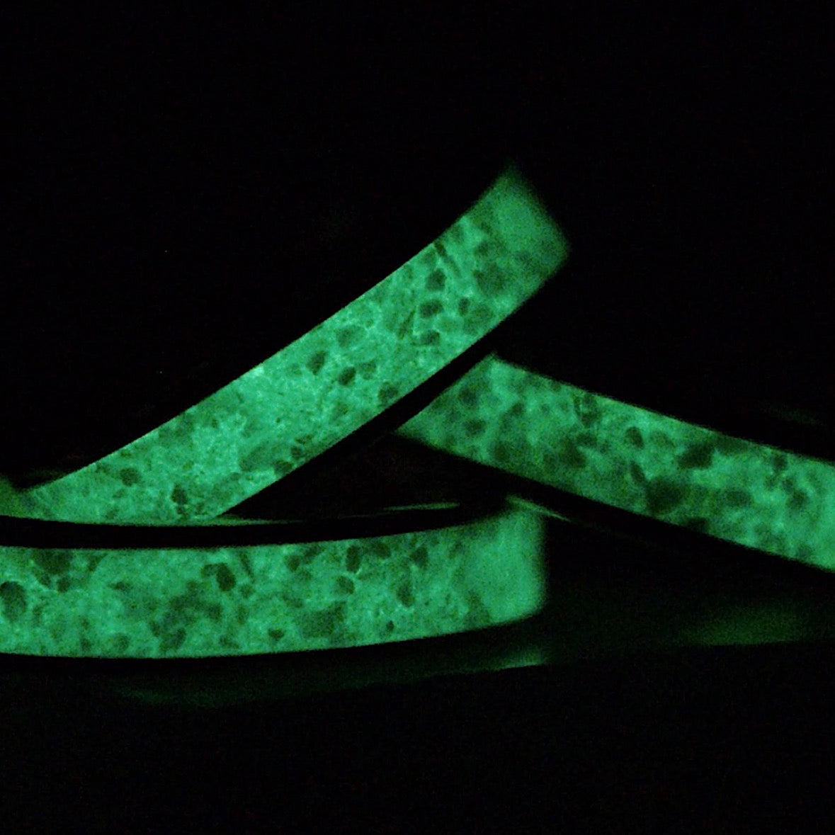 Three rings stacked on top of each other with green glow powder inside glowing in the dark