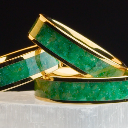 Three gold plated tungsten rings stacked on top of one another with crushed jade gemstone inside