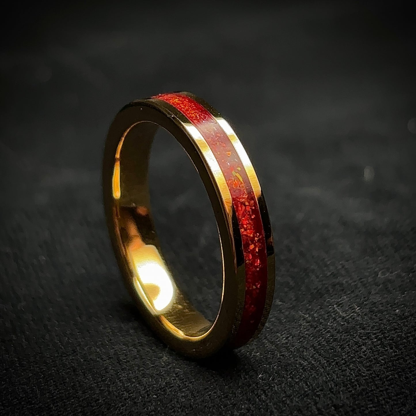 Gold plated tungsten ring with red synthetic opal inside