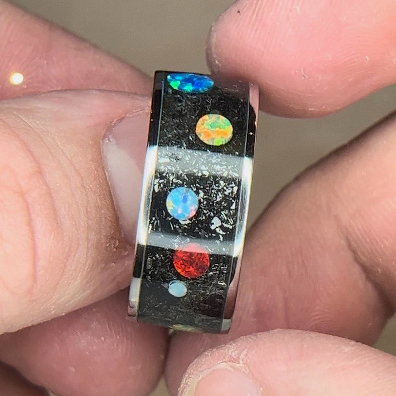 Titanium ring with meteorite shavings and multi-color synthetic opal cabochons to resemble a planet and space design