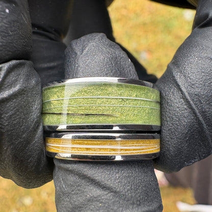 Two stainless steel rings with green and yellow pigment powders and cat whiskers inside